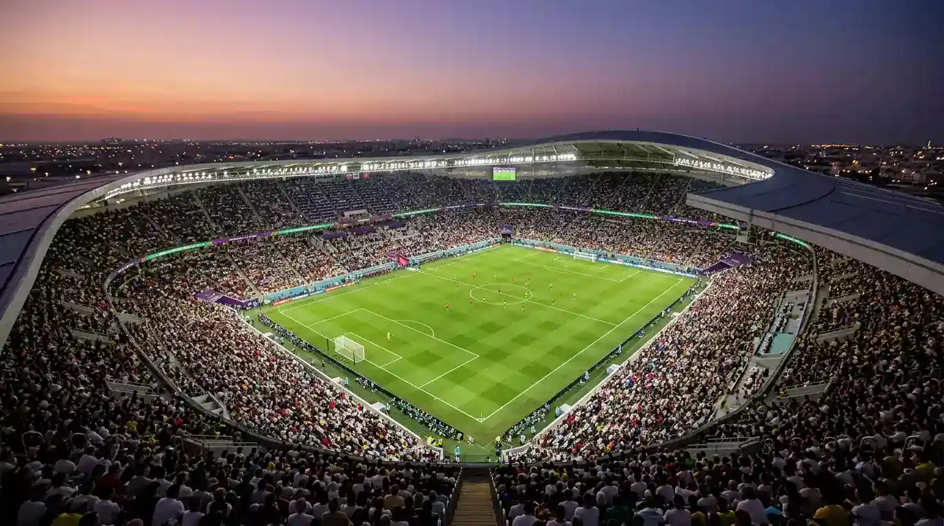 Vista aérea del MetLife Stadium iluminado en la noche durante el Mundial 2026 con balones del torneo y banderas de selecciones